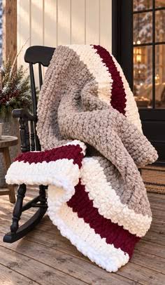 Burgundy, cream, and taupe striped chunky knit blanket on a porch rocking chair