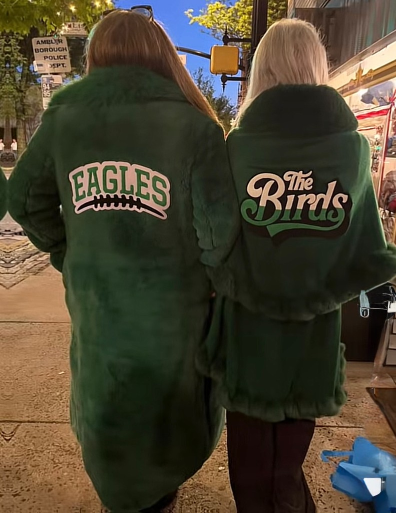 Two guests from behind in green coats customized with Eagles and The Birds patches at Patch Your Pride