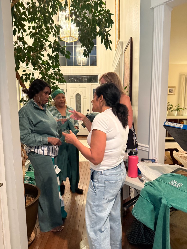 Guests talking and looking at green apparel in the entryway at Patch Your Pride