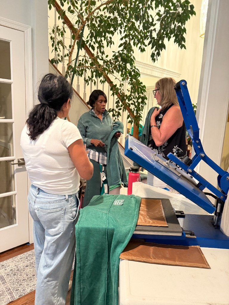 A heat press set up with a green garment during the Patch Your Pride event