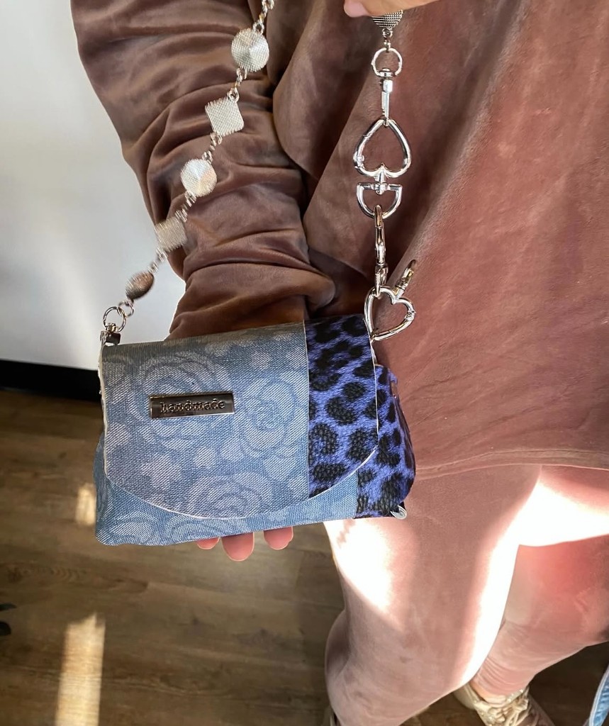 A participant holding a finished blue denim and leopard handmade purse