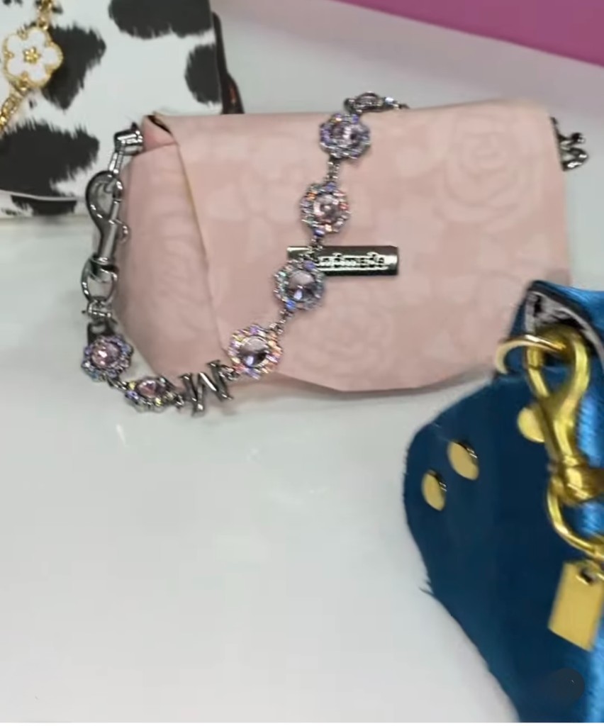 A blush pink handmade purse with a crystal chain