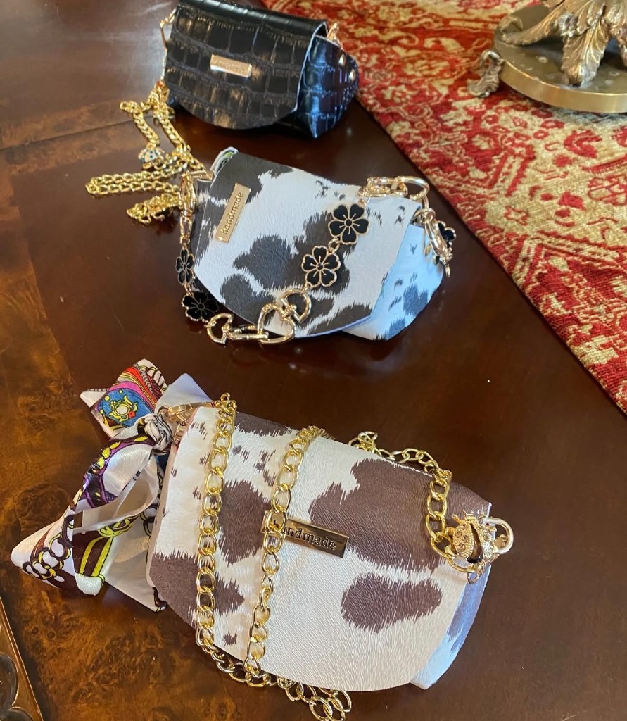 Three finished handmade purses arranged on a wood table